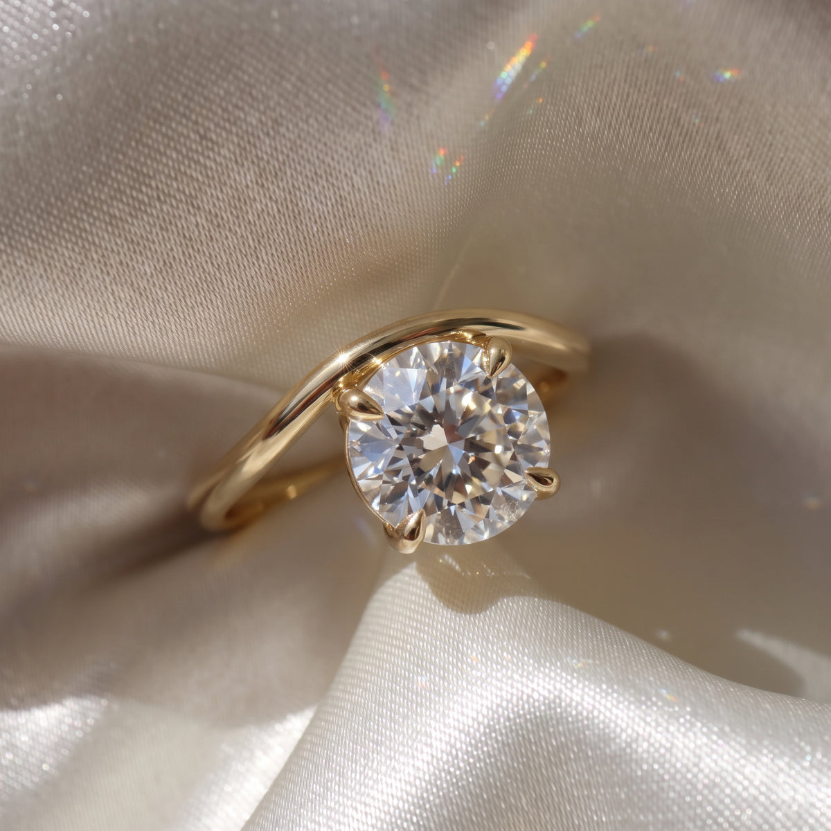 The Solis Ring — Curved East West Round Cut on a luxurious silk fabric | The Jewel Concierge