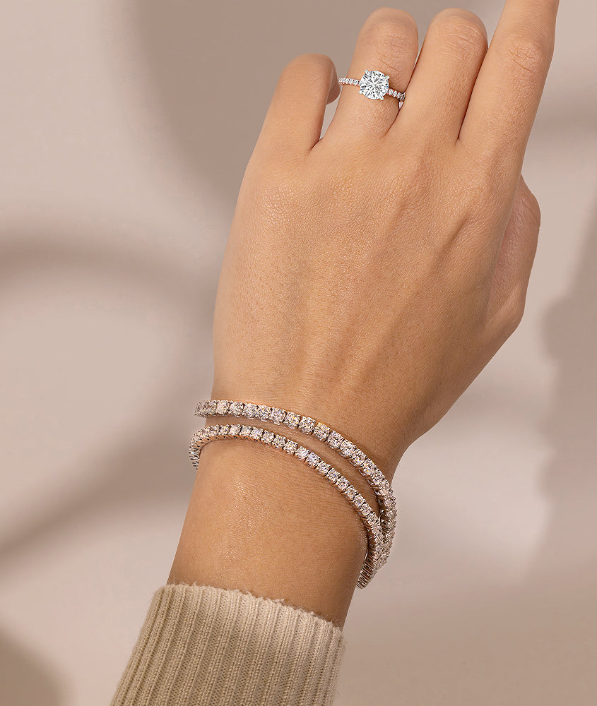 beautiful diamond tennis bracelets on a woman's wrist with a  lab-grown diamond solitaire engagement ring