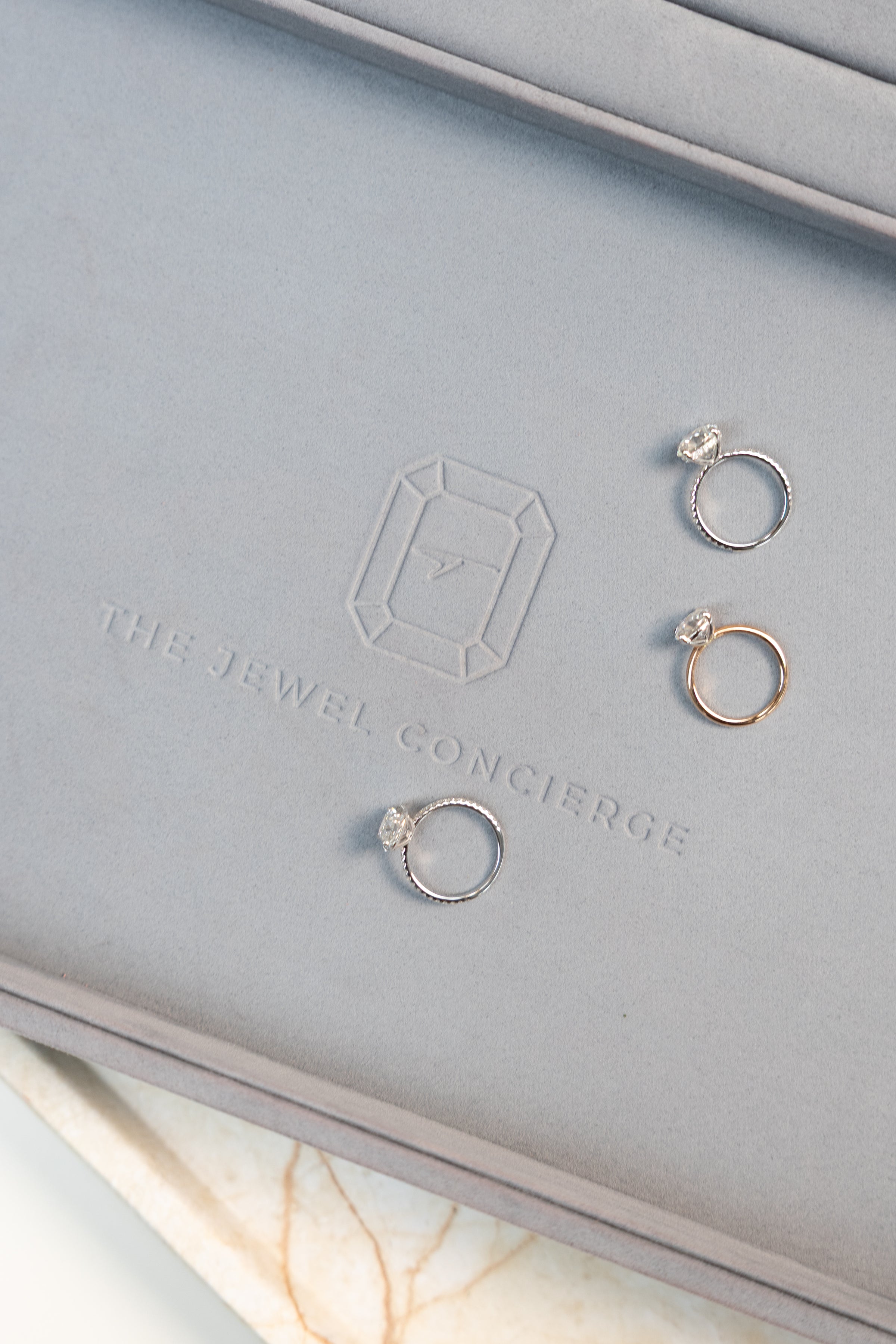 three stunning engagement rings on a luxorious greyish blue jewellery tray