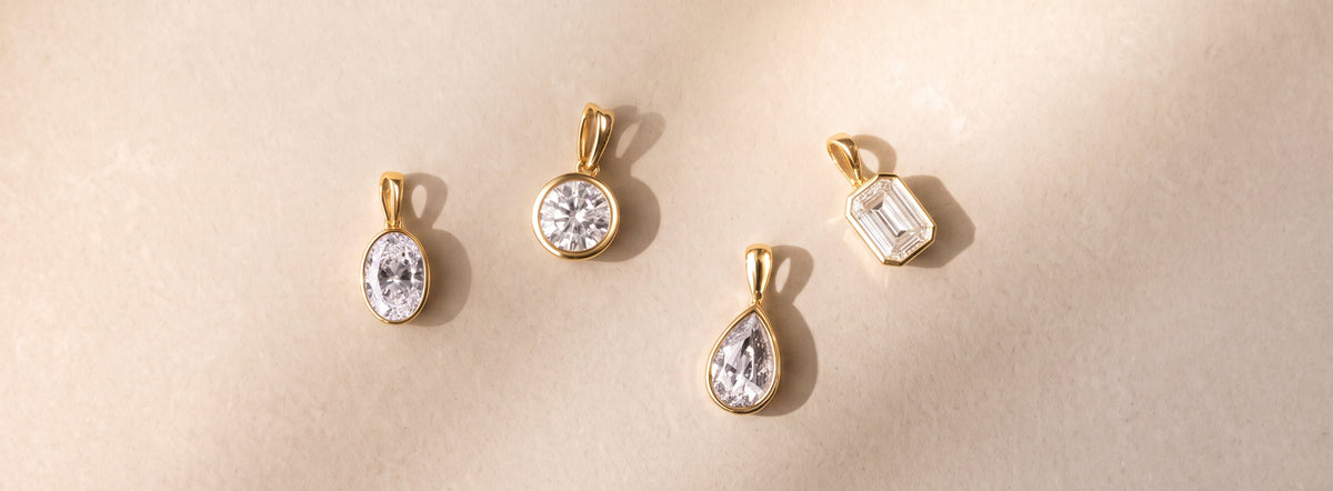 The Odette Pendant - Bezel solitaire on a limestone background | The Jewel Concierge
