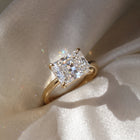 The Aria Ring — East-West Radiant Solitaire Lab-Grown Diamond Engagement Ring in Yellow Gold on a Luxurious Silk Fabric  | The Jewel Concierge