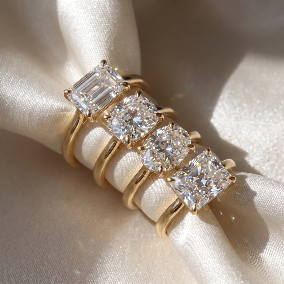 The Aria Ring - East-West Cathedral Solitaire in assortment of diamond shapes, elegantly laid on a luxurious silk fabric - The Jewel Concierge