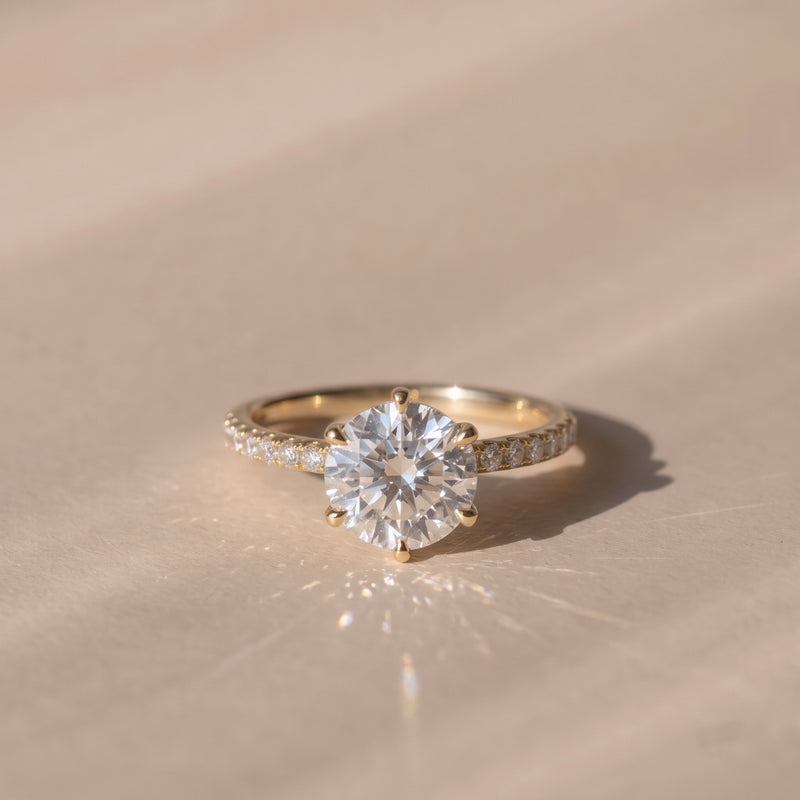 The Astra Ring — 6 Claw Round Solitaire with Pavé Band Lab-Grown Diamond Engagement Ring in Yellow Gold | The Jewel Concierge