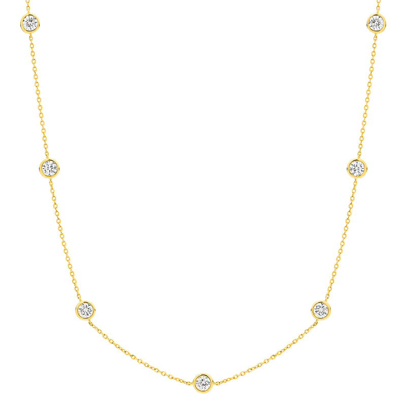 A delicate bezel by the yard gold chain necklace featuring nine small, round bezel-set clear lab-grown diamonds spaced evenly along the chain, displayed against a solid white background  - The Jewel Concierge