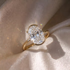 The Celine Ring — Oval Half Bezel Solitaire Lab-Grown Diamond Engagement Ring in Yellow Gold on Silk Fabric | The Jewel Concierge