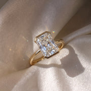 The Celine Ring — Radiant Half Bezel Solitaire Lab-Grown Diamond Engagement Ring in Yellow Gold on a luxurious silk fabric | The Jewel Concierge