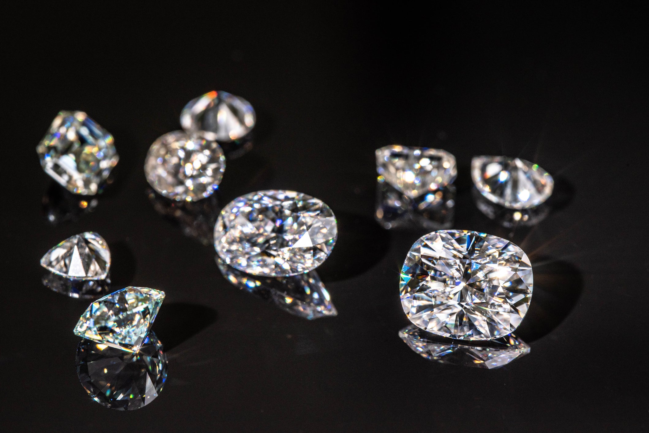 Collection of beautiful diamonds on a reflective black surface