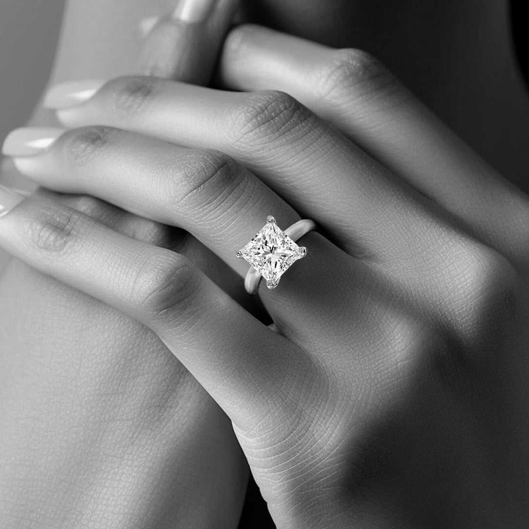 close-up of woman's hand with a radiant diamond engagement ring in black & white