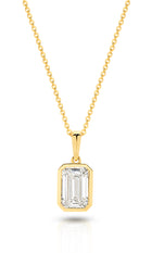 A yellow gold pendant featuring an emerald lab-grown diamond, set in a bezel setting against a clean white background with a soft reflection - The Jewel Concierge