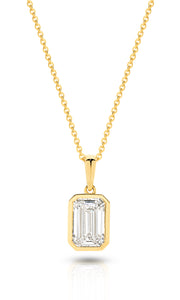 A yellow gold pendant featuring an emerald lab-grown diamond, set in a bezel setting against a clean white background with a soft reflection - The Jewel Concierge