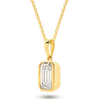 A yellow gold pendant featuring an emerald lab-grown diamond, set in a bezel setting against a clean white background with a soft reflection - The Jewel Concierge