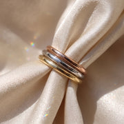 The Emily Ring - plain half rounded wedding band, laid elegantly on a luxurious silk fabric | The Jewel Concierge