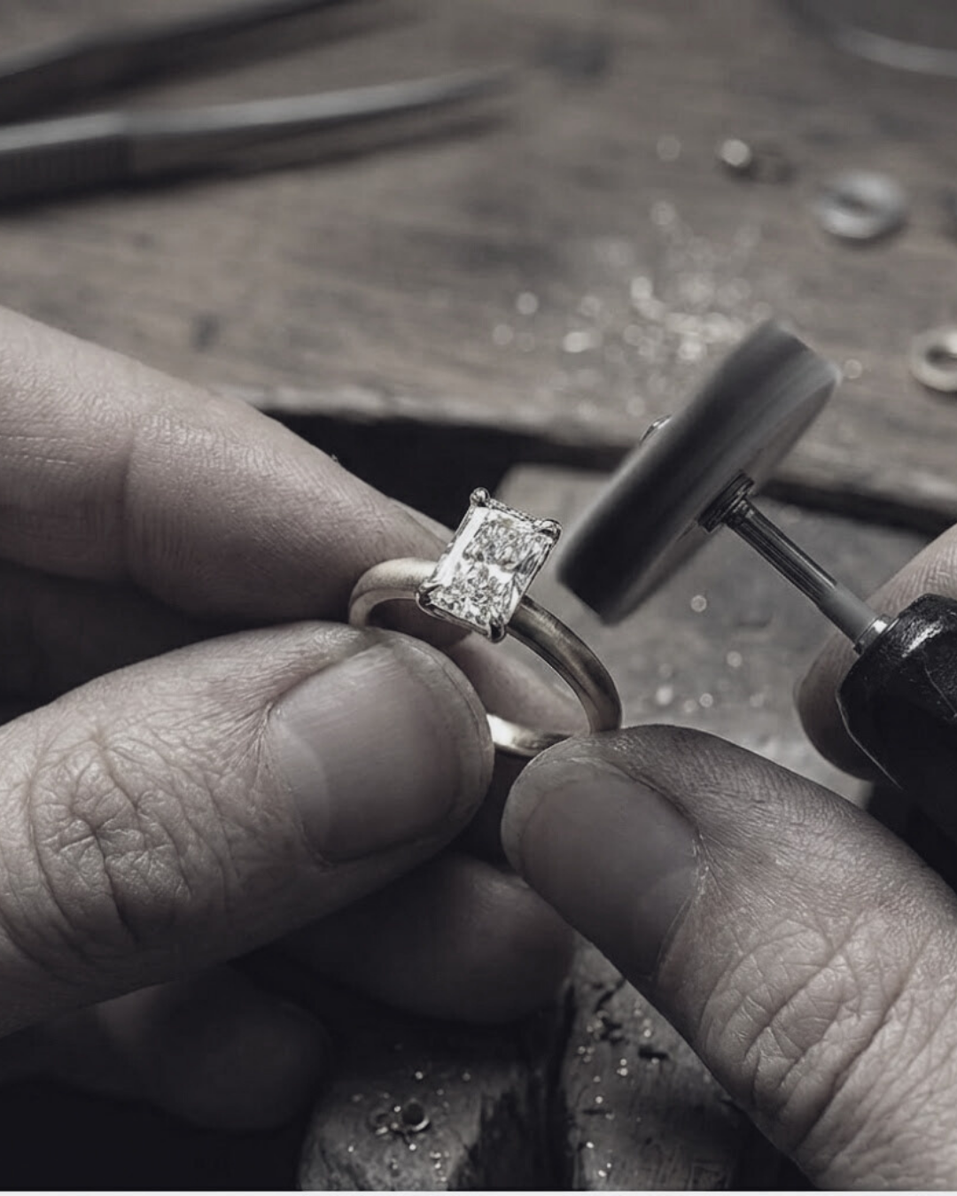Black and white photo of a Jeweller handcrafting The Nova Ring - Emerald Solitaire in 18K Yellow Gold - The Jewel Concierge