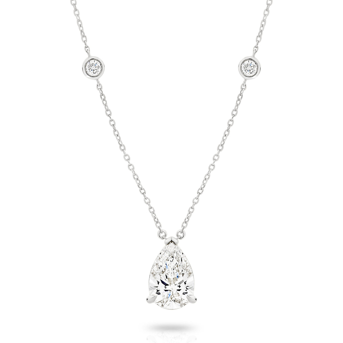 A white gold necklace featuring a delicate chain with five small round bezel-set lab-grown diamonds spaced along the chain, ending with a pear-cut lab-grown diamond solitaire, shown on a white background - The Jewel Concierge