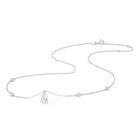A white gold necklace featuring a delicate chain with five small round bezel-set lab-grown diamonds spaced along the chain, ending with a pear-cut lab-grown diamond solitaire, shown on a white background - The Jewel Concierge