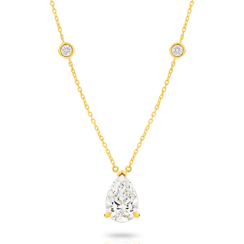 A yellow gold necklace featuring a delicate chain with five small round bezel-set lab-grown diamonds spaced along the chain, ending with a pear-cut lab-grown diamond solitaire, shown on a white background - The Jewel Concierge