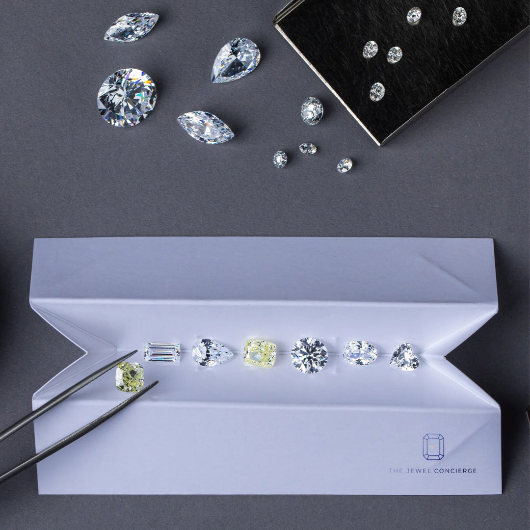 diamond envelope with various diamond sahpes n different colors on a luxurious blue grey backgruond | The Jewel Concierge