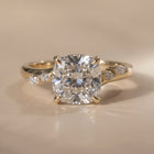 The Madeline Ring — Cushion with Twisted Accent Band Lab-Grown Diamond Engagement Ring on a luxurious beige background | The Jewel Concierge