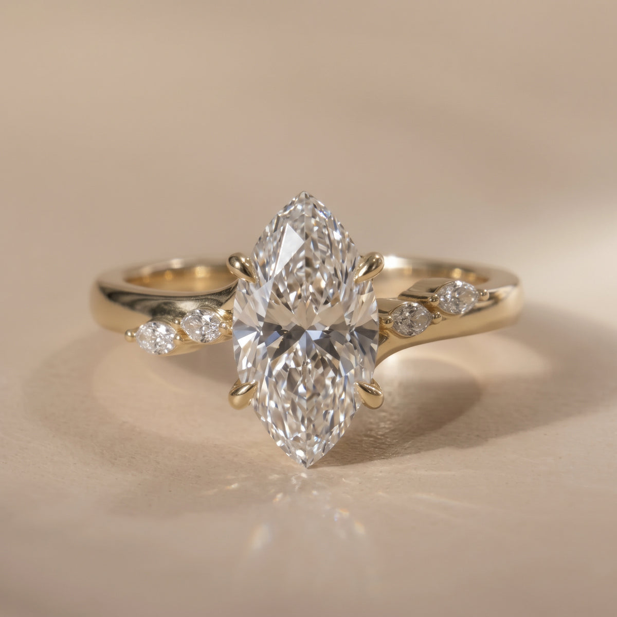 The Madeline Ring — Marquise with Twisted Accent Band Lab-Grown Diamond Engagement Ring on a warm beige background | The Jewel Concierge