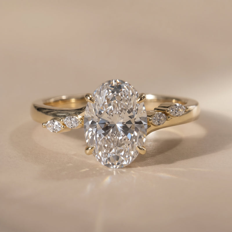 The Madeline Ring — Oval with Twisted Accent Band Lab-Grown Diamond Engagement Ring on a warm beige background | The Jewel Concierge