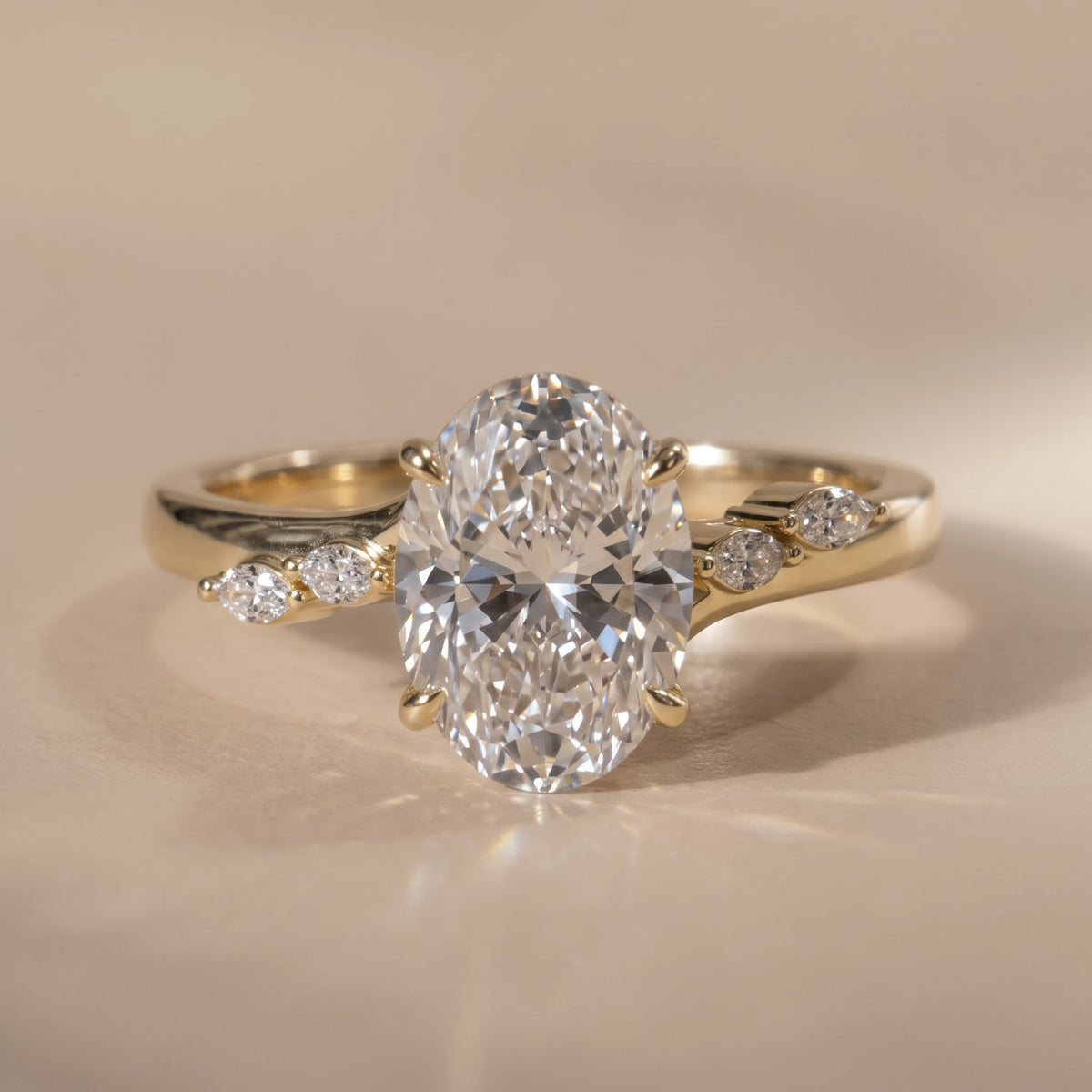 The Madeline Ring — Oval with Twisted Accent Band Lab-Grown Diamond Engagement Ring on a warm beige background | The Jewel Concierge
