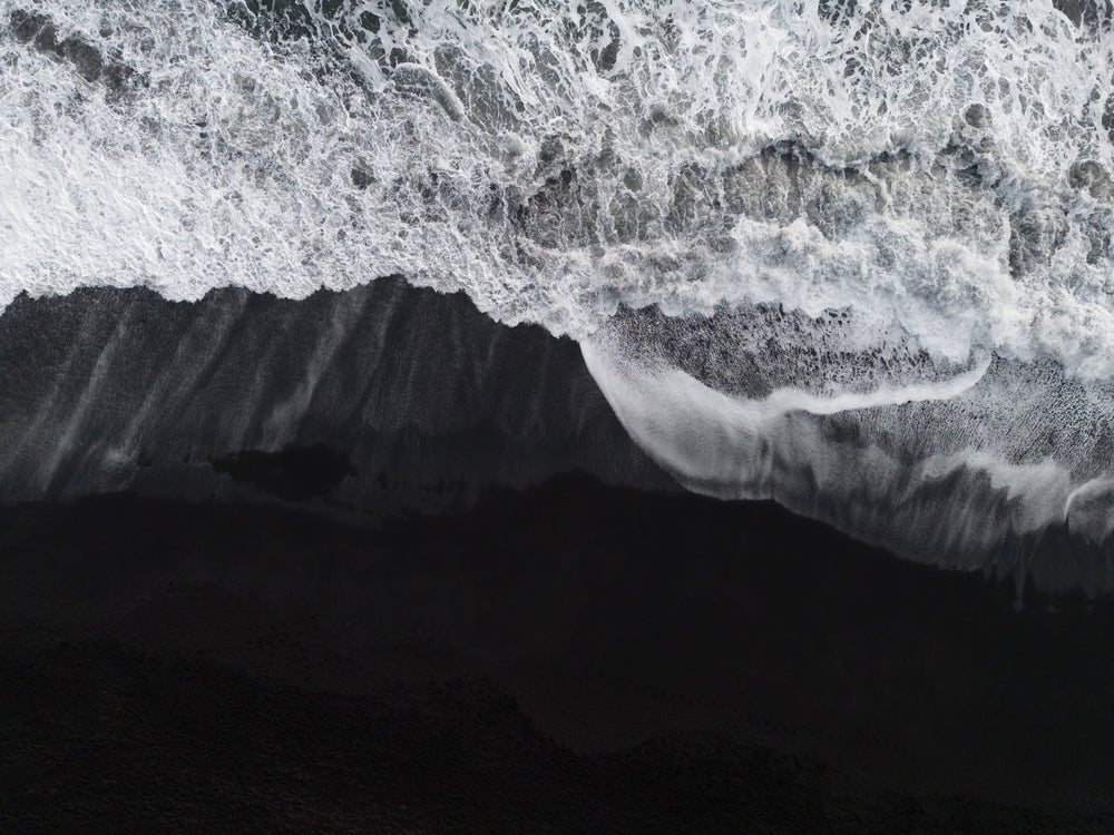 foamy waves breaking on a black sand beach