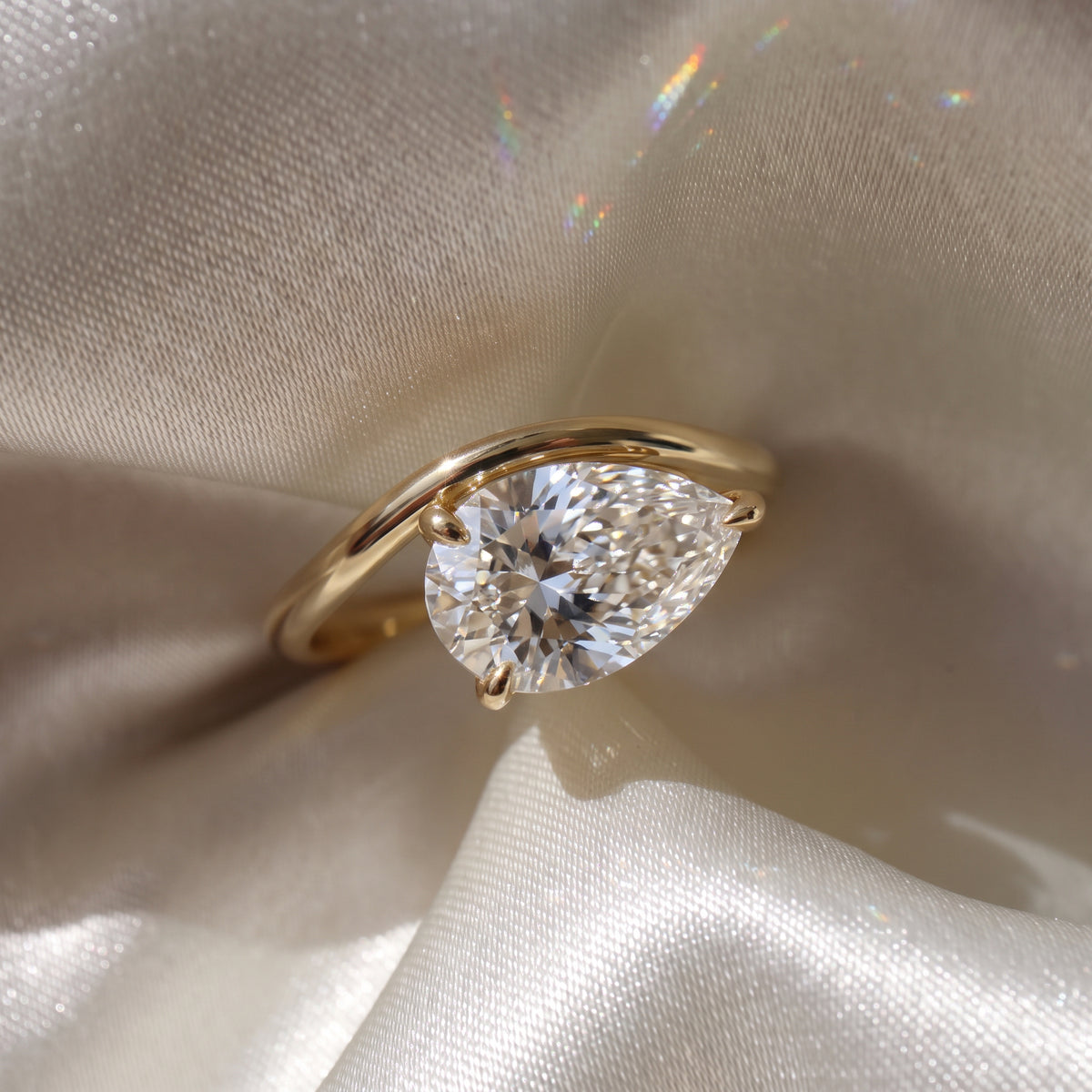 The Solis Ring — Curved East West Pear Cut on a luxurious silk fabric | The Jewel Concierge