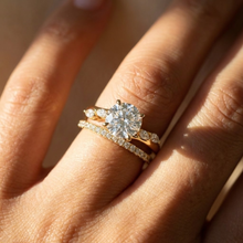 Close-up of a hand wearing a diamond ring with a matching band.
