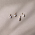 Four Odette Bezel pendants in yellow gold, elegantly laid on a luxurious grey background - The Jewel Concierge