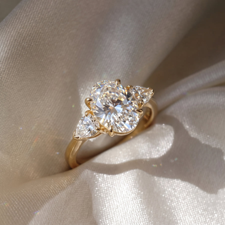 The Vivienne Ring - Oval and pear trilogy in 18K yellow gold on a luxurious silk fabric - The Jewel Concierge