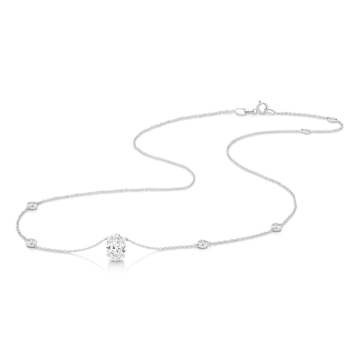 A white gold necklace featuring a delicate chain with five small round bezel-set lab-grown diamonds spaced along the chain, ending with an oval-cut lab-grown diamond solitaire pendant, shown on a white background - The Jewel Concierge