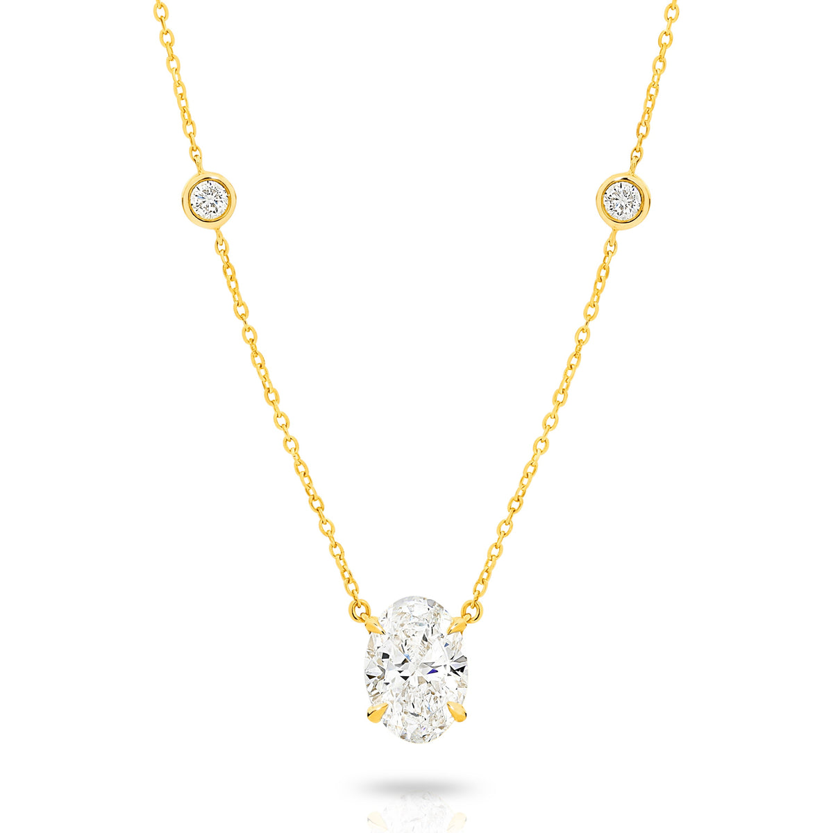 A yellow gold necklace featuring a delicate chain with five small round bezel-set lab-grown diamonds spaced along the chain, ending with an oval-cut lab-grown diamond solitaire pendant, shown on a white background - The Jewel Concierge
