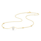 A yellow gold necklace featuring a delicate chain with five small round bezel-set lab-grown diamonds spaced along the chain, ending with an oval-cut lab-grown diamond solitaire pendant, shown on a white background - The Jewel Concierge