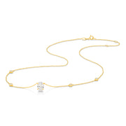 A yellow gold necklace featuring a delicate chain with five small round bezel-set lab-grown diamonds spaced along the chain, ending with an oval-cut lab-grown diamond solitaire pendant, shown on a white background - The Jewel Concierge