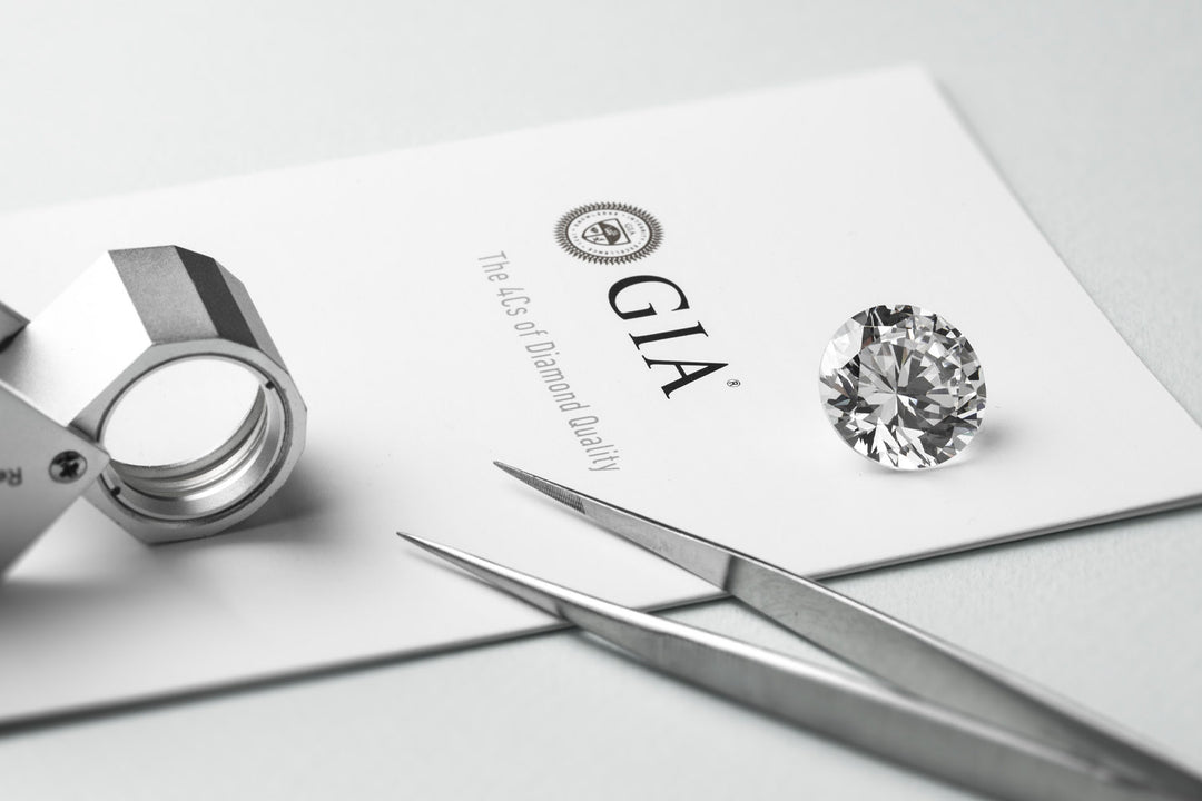 round diamond on a GIA certificate with a loupe and tweezers